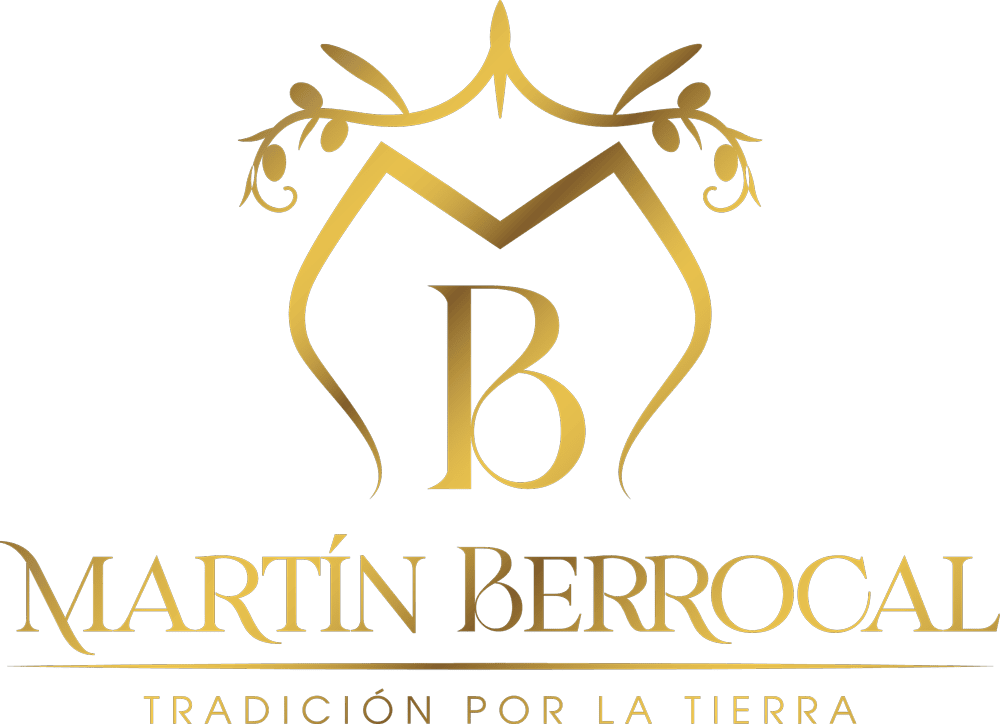 Logotipo dorado con diseño ornamentado con una "M" y una "B", con el texto debajo que dice "MARTÍN BERROCAL" y el lema "TRADICIÓN POR LA TIERRA. Este emblema sirve como kit por defecto de nuestra distinguida marca.