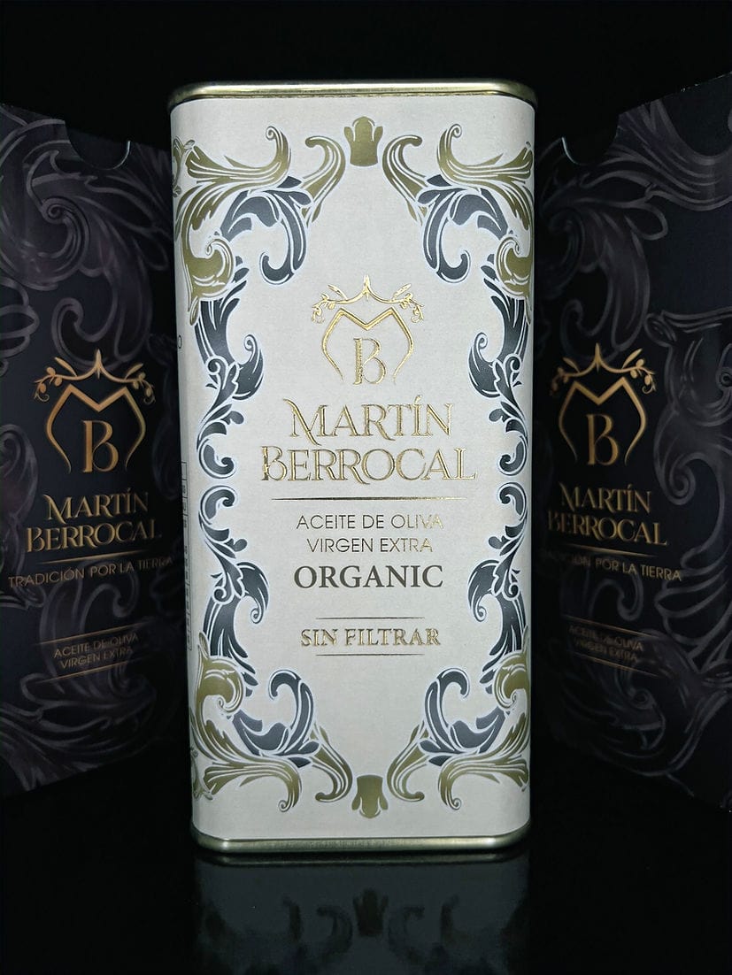 A can of UNFILTERED Organic Extra Virgin Olive Oil 500ml, adorned with elegant floral designs.
Two similar cans are partially visible in the background.